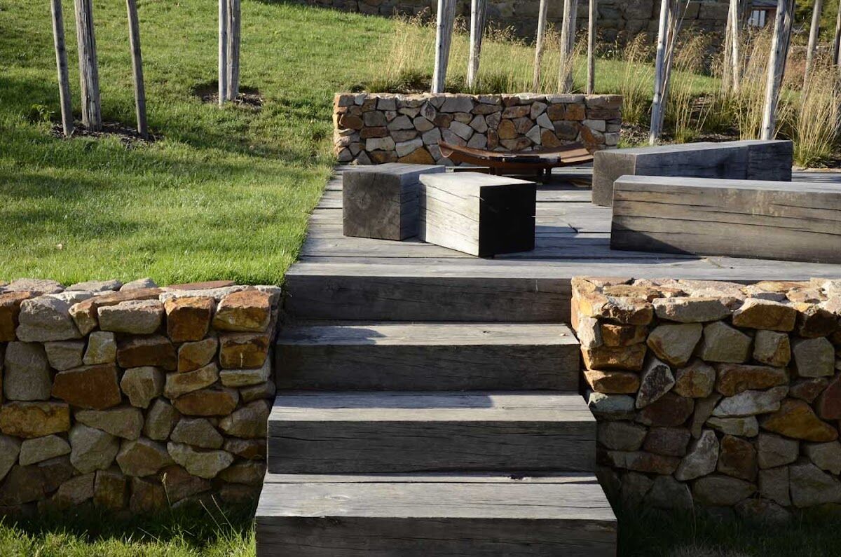 Terasa s kamennými zídkami a dřevěným posezením